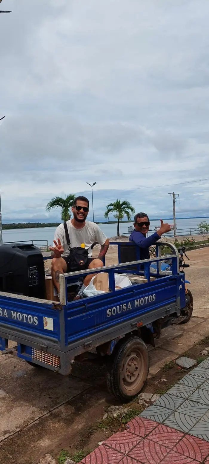 Equipe chegando de triciclo com o equipamento de cinema